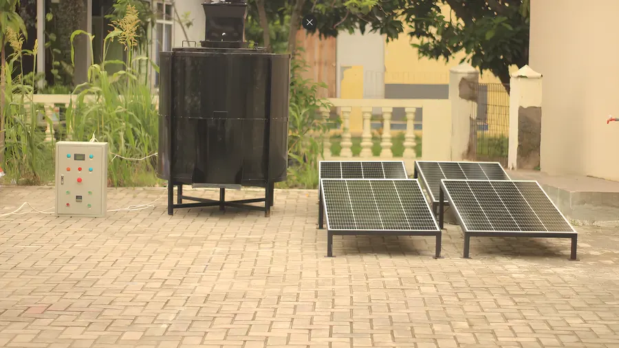Padiku rice dryer and local control cabinet with solar panels beside the drying chamber.