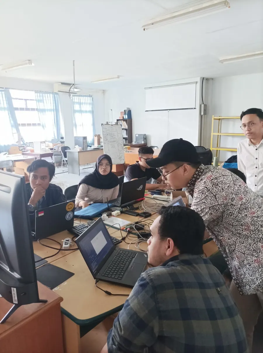 Project team gathered around laptops in a lab workspace.