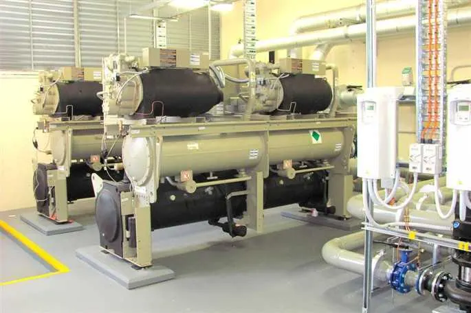 Water-cooled chiller in the plant room with existing pipework and control cabinets.